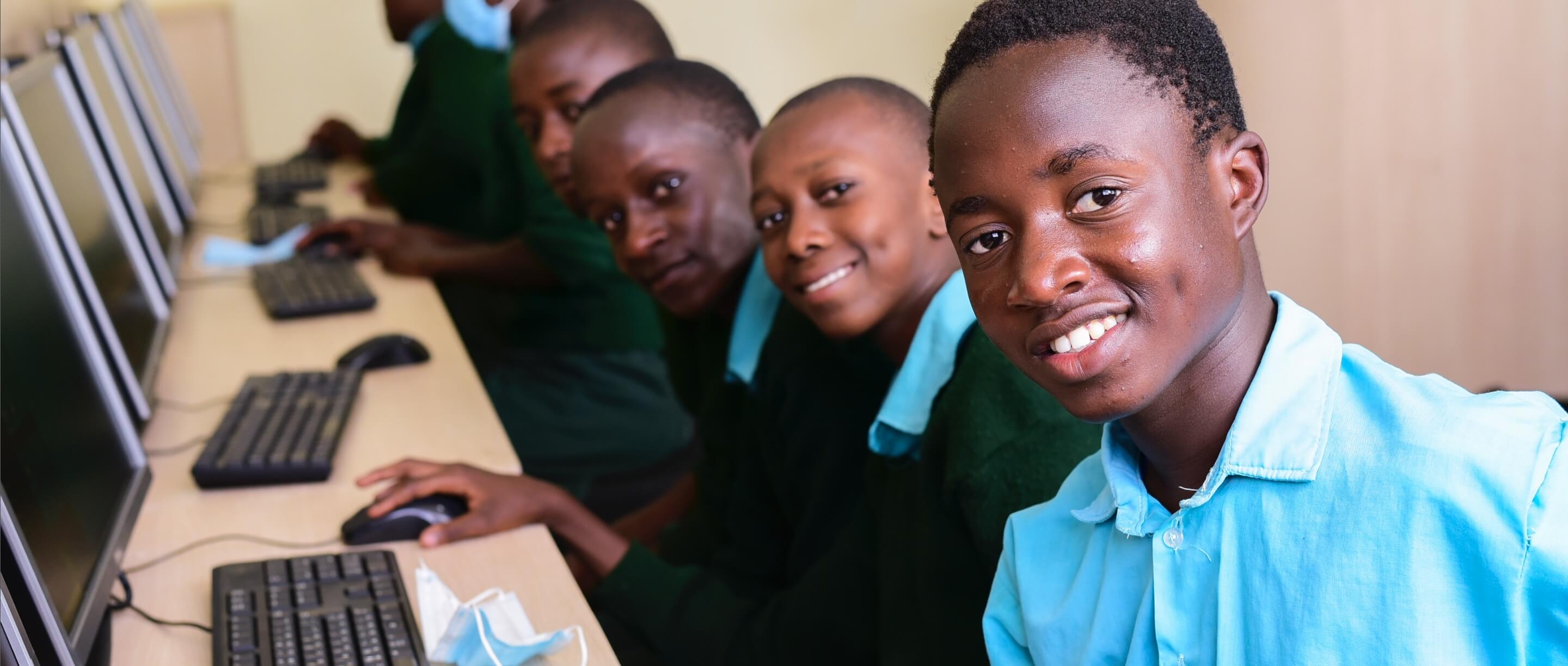 students smiling in a computer lab